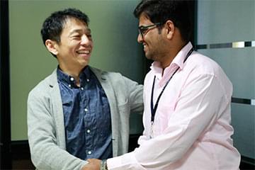 株式会社IBJの社長とインド人内定者が大学で握手